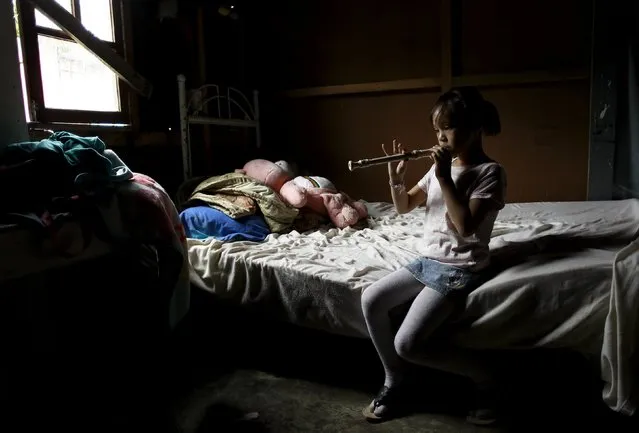 Lisandra Perez, 7, practices in his house before his flute lesson at the Integral System of Artistic Education for Social Inclusion (SIFAIS) center in the poor neighborhood of La Carpio, Costa Rica October 8, 2015. (Photo by Juan Carlos Ulate/Reuters)
