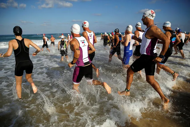 Participants run into the Mediterranean Sea as they begin the swimming section of a triathlon in Ashdod, Israel September 23, 2016. (Photo by Amir Cohen/Reuters)