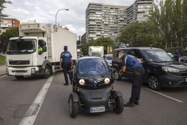 Local police stop vehicles at a checkpoint in Madrid, Spain, Wednesday, September 23, 2020. Madrid is poised to extend its restrictions on movement to more neighborhoods, due to a surge in new cases in other districts and despite an outcry from residents over discrimination. Police on Monday deployed to 37 working-class neighborhoods that have seen 14-day transmission rates above 1,000 per 100,000 inhabitants. (Photo by Bernat Armangue/AP Photo)