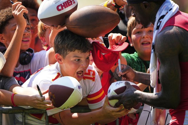 Fans react as Kansas City Chiefs wide receiver Xavier Worthy, right, signs autographs at the team's NFL football training camp Sunday, July 27, 2025, in St. Joseph, Mo. (Photo by Charlie Riedel/AP Photo)
