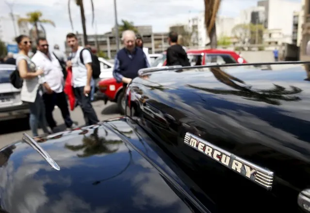 People observe a 1947 Mercury during the 25th edition of the "1000 millas sport e historicos" (1000 miles sports and classic) race in Montevideo, October 28, 2015. (Photo by Andres Stapff/Reuters)