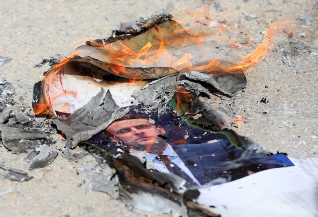 Palestinians burn pictures of the French President Emmanuel Macron during a protest in Palestine Technical University in al-Aroub, north of the West Bank city of Hebron, 27 October 2020. The protest was organized in response to French President Emmanuel Macron's comments that his country would not give up publishing Prophet Muhammad's cartoons following the recent beheading of a teacher in France after he had shown such cartoons in class. (Photo by Abed Al Hashlamoun/EPA/EFE)