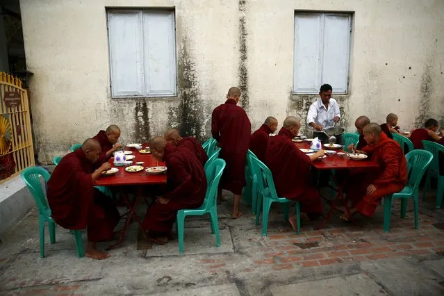 Buddhist monks eat breakfast outside a monastery in Mandalay October 7, 2015. (Photo by Jorge Silva/Reuters)