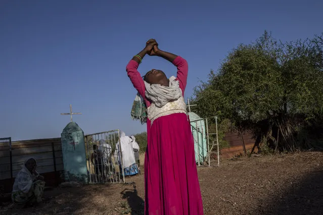 A Tigrayan woman who fled the conflict in Ethiopia's Tigray region stretches her arms after Sunday Mass ends at a nearby church, at Umm Rakouba refugee camp in Qadarif, eastern Sudan, November 29, 2020. (Photo by Nariman El-Mofty/AP Photo)