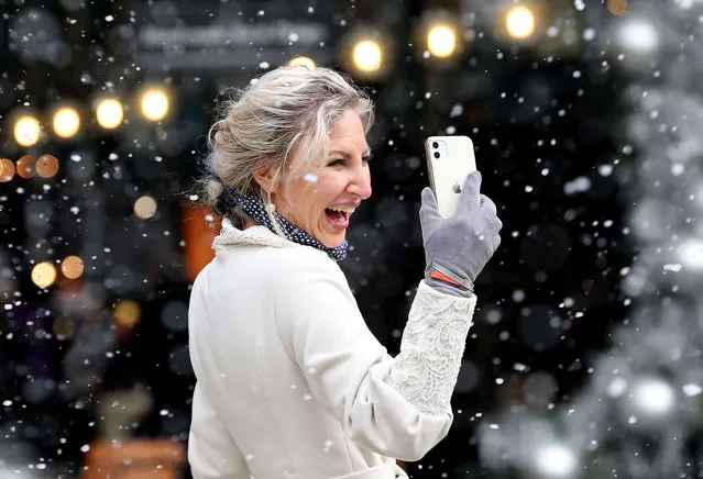 A woman enjoys the artificial snow-fall as Covent Garden welcomes back shoppers and diners after UK lockdown at Covent Garden on December 02, 2020 in London, England. (Photo by Chris Jackson/Getty Images)