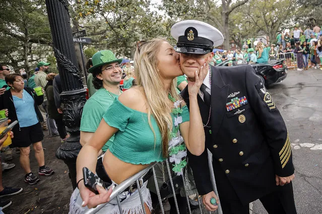 Kelsey Goran of Kennesaw, Ga., left, kisses a sailor from the USS Alaska as he marches in the 194-year-old Savannah St. Patrick's Day parade, Saturday, March 17, 2018, during the St. Patrick's Day parade in Savannah, Ga. Vice President Mike Pence participated Saturday in the South's largest St. Patrick's Day parade, where a few lucky fans behind sidewalk barricades got hugs or selfies and a small band of protesters followed nearby waving signs and rainbow flags. (Photo by Stephen B. Morton/AP Photo)