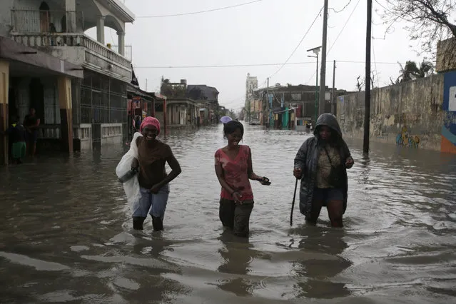 People walk in a flooded street during rain after Hurricane Matthew in Les Cayes, Haiti, October 21, 2016. (Photo by Andres Martinez Casares/Reuters)