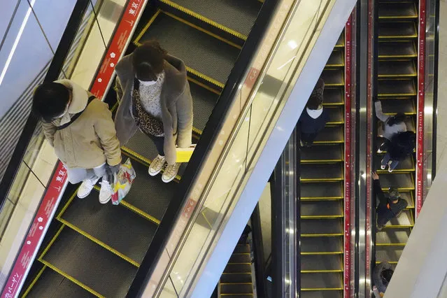 People wearing protective masks to help curb the spread of the coronavirus take usually crowded escalators at a shopping arcade in Tokyo Saturday, January 9, 2021. The Japanese capital confirmed more than 2200 new coronavirus cases on Saturday. Japanese Prime Minister Yoshihide Suga declared a state of emergency last Thursday for Tokyo and three other prefectures to ramp up defenses against the spread of the coronavirus. (Photo by Eugene Hoshiko/AP Photo)