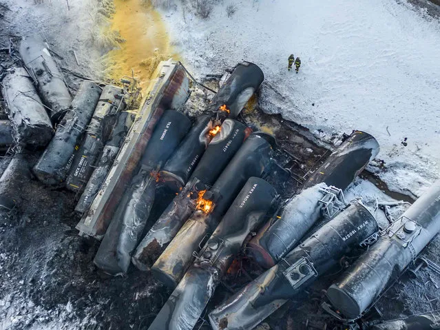 Firefighters stand near piled up train cars, near Raymond, Minn., Thursday, March 30, 2023, the morning after a BNSF freight train derailed. Authorities say a train hauling ethanol and corn syrup derailed and caught fire and residents within 1/2 mile of the crash were ordered to evacuate from their homes. (Photo by Kerem Yücel/Minnesota Public Radio via AP Photo)