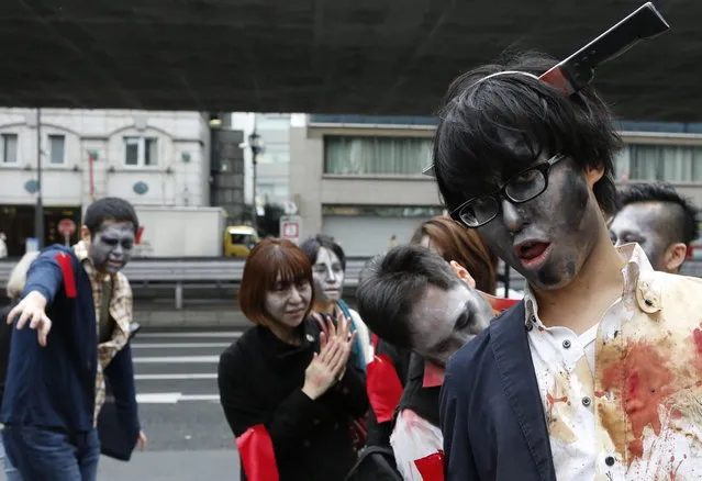 People, dressed as zombies, participate in the Roppongi Zombie Walk in Tokyo March 31, 2013. About 50 people dressed up as zombies early evening on Sunday, catching the attention of pedestrians on the streets of Tokyo's downtown Roppongi district. (Photo by Yuya Shino/Reuters)