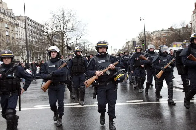 French police officers arrive to take up positions near Porte de Vincennes in Paris on January 9, 2015, after at least one person was injured when a gunman opened fire at a kosher grocery store and took at least five people hostage, sources told AFP. The attacker was suspected of being the same gunman who killed a policewoman in a shooting in Montrouge in southern Paris on January 8. (Photo by Loic Venance/AFP Photo)
