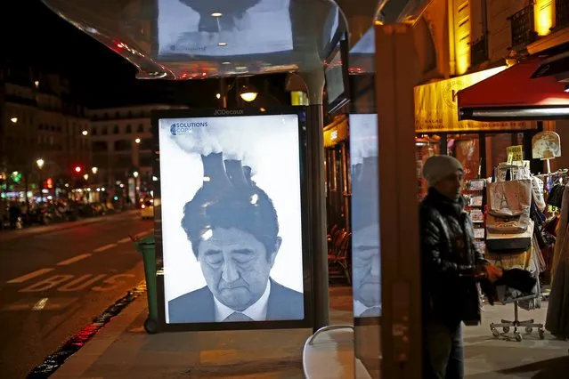 A poster by street artist Bill Posters, showing a satirical portrait of Japan's Prime Minister Shinzo Abe, as part of the "Brandalism" project is displayed at a bus stop in Paris, France, November 28, 2015, ahead of the United Nations COP21 Climate Change conference in Paris. (Photo by Benoit Tessier/Reuters)