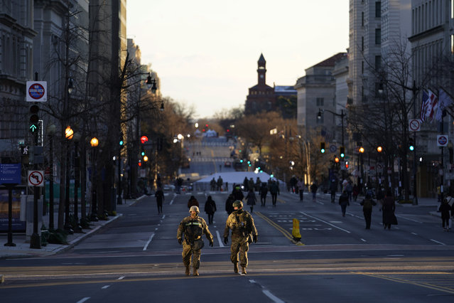 National Guards patrol empty streets ahead of President-elect Joe Biden's inauguration ceremony, Tuesday, January 19, 2021, in Washington. (Photo by Matt Slocum/AP Photo)