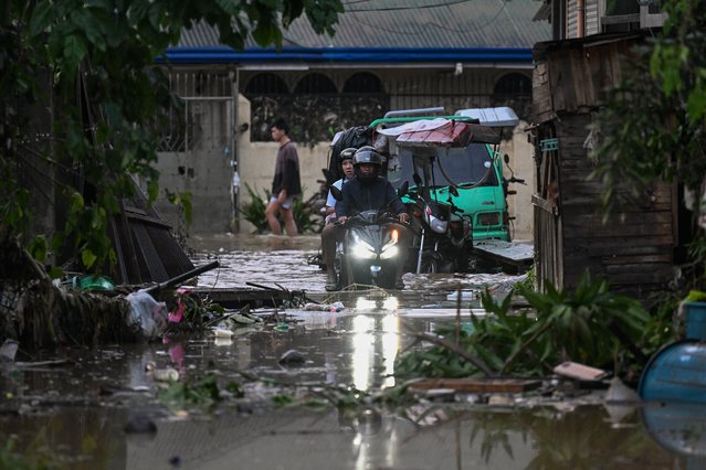 A motorcyclist travels through a flooded street in the aftermath of Typhoon Kalmaegi in Mandaue City, Cebu province on November 5, 2025. (Photo by Jam Sta Rosa/AFP Photo)