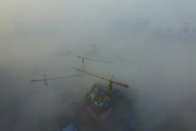 Cranes are seen above a construction site amid heavy fog in Xi'an, Shaanxi province, China, November 29, 2015. (Photo by Reuters/Stringer)