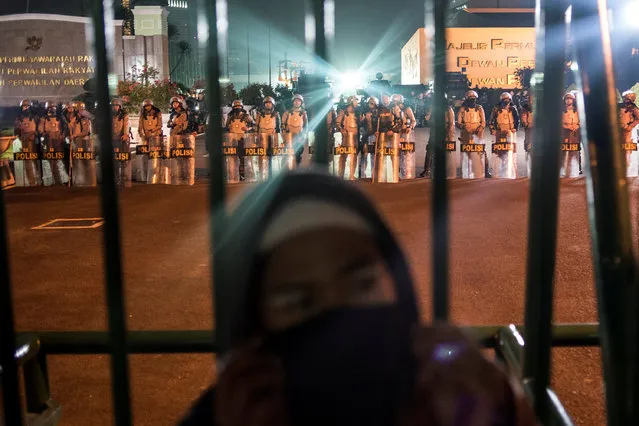 A hardline Muslim protester stands in front of Parliament building as policemen stand guard during a protest against Jakarta's incumbent governor Basuki Tjahaja Purnama, an ethnic Chinese Christian running in the upcoming election, in Jakarta, Indonesia, November 4, 2016 in this picture taken by Antara Foto. (Photo by Sigid Kurniawan/Reuters/Antara Foto)