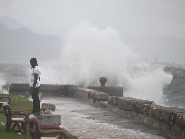 A man watches the waves crash into the walls at the Kingston Waterfront on October 27, 2025. Hurricane Melissa threatened Jamaica with potentially deadly rains after rapidly intensifying into a top-level Category 5 storm, as residents scrambled for shelter from what could be the island's most violent weather on record. Melissa has already been blamed for at least four deaths in Haiti and the Dominican Republic, and was set to unleash torrential rains on parts of Jamaica in a direct hit on the Caribbean island. (Photo by Ricardo Makyn/AFP Photo)