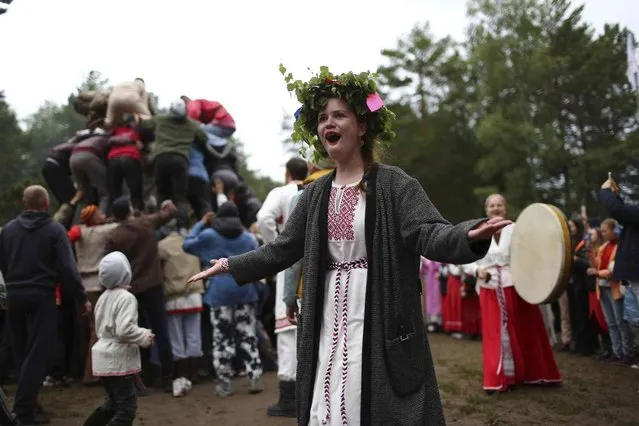 A woman wearing traditional Russian village-style clothes dances while celebrating the summer solstice in the village of Okunevo, about 200 kilometers (about 125 miles) northeast of the Siberian city of Omsk, Russia, on Wednesday, June 21, 2023. (Photo by Evgeniy Sofiychuk/AP Photo)