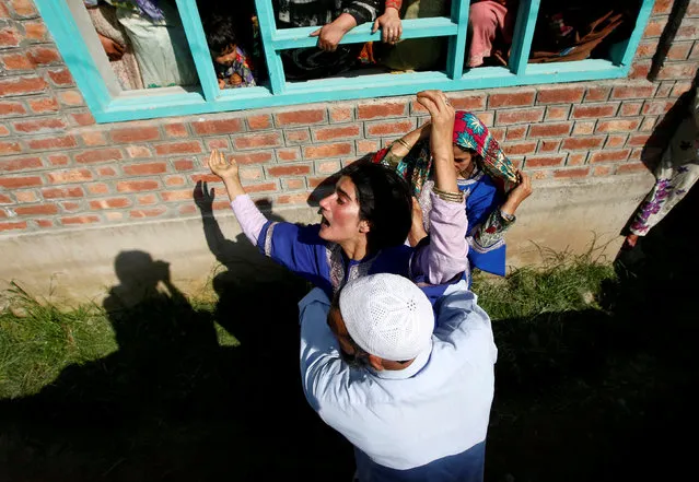 A man tries to console a woman as she watches the body of Tamsheel Ahmad Khan, a civilian who according to local media died during clashes between protesters and Indian security forces, during his funeral at Vehil village in Kashmir's Shopian district, July 10, 2018. (Photo by Danish Ismail/Reuters)