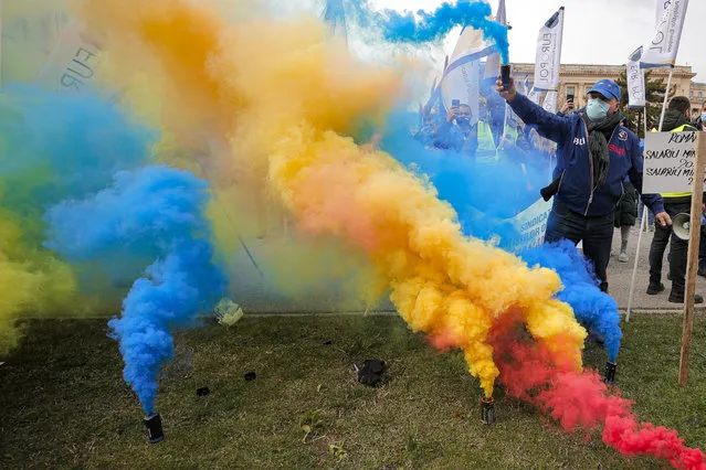 Protesters from the police trade unions set off smoke grenade in the colors of the national flag during a rally in Bucharest, Romania, Thursday, March 25, 2021. (Photo by Vadim Ghirda/AP Photo)
