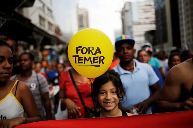 A girl holds a balloon that reads “Out Temer”, referring to Brazil's President Michel Temer, during a protest against a constitutional amendment, known as PEC 55, that limits public spending, in Sao Paulo, Brazil, November 27, 2016. (Photo by Nacho Doce/Reuters)