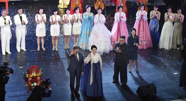 South Korean President Moon Jae-in, front left, and his wife Kim Jung-sook wave to the audience after watching an art performance as North Korean leader Kim Jong Un, bottom second from right, and his wife Ri Sol Ju look on at Pyongyang Grand Theatre in Pyongyang, North Korea, Tuesday, September 18, 2018. (Pyongyang Press Corps Pool via AP Photo)