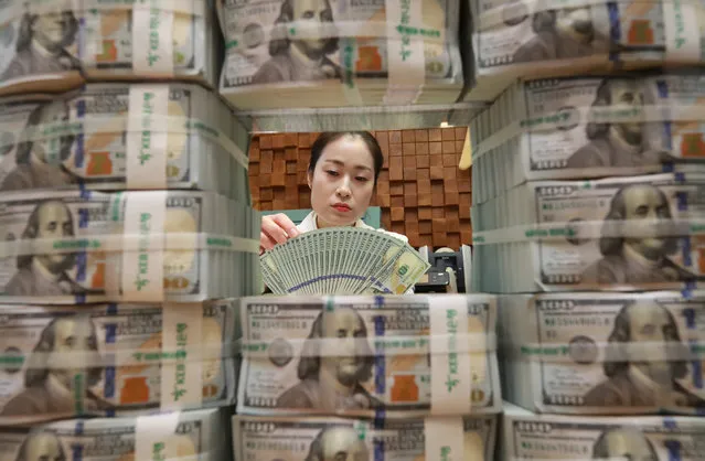 A clerk scrutinizes 100-dollar US banknotes for counterfeits at the headquarters of KEB Hana Bank in Seoul, South Korea, 04 May 2018. South Korea's foreign exchange reserves set a new record high for the second month in a row in April with increased gains from investment in foreign assets. As of the end of April, the country's foreign exchange reserves came to 398.42 billion US dollar, up $1.67 billion US dollar from a month earlier, according to the data by the Bank of Korea. (Photo by EPA/EFE/Yonhap)