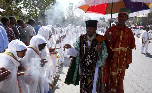 An Ethiopian orthodox priest blesses the faithful with incense during Ethiopia's Timket celebration to commemorate the baptism of Jesus Christ by John the Baptist in the river Jordan, in Gondar, Ethiopia, January 19, 2016. (Photo by Tiksa Negeri/Reuters)