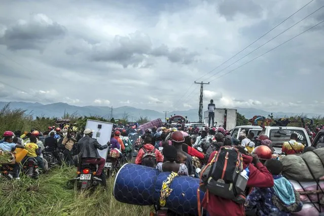 Residents flee Goma, Congo Thursday, May 27, 2021 , five days after Mount Nyiragongo erupted . A new eruption could occur at any moment, the military governor of Congo's North Kivu province, Lt. Gen. Constat Ndima Kongba, announced early Thursday. He ordered the evacuation of 10 of the 18 neighborhoods in the city of 2 million people. The center of Goma, which was spared when the volcano erupted last week, is now under threat, with activity being reported near the urban area and Lake Kivu, Kongba said. (Photo by Moses Sawasawa/AP Photo)