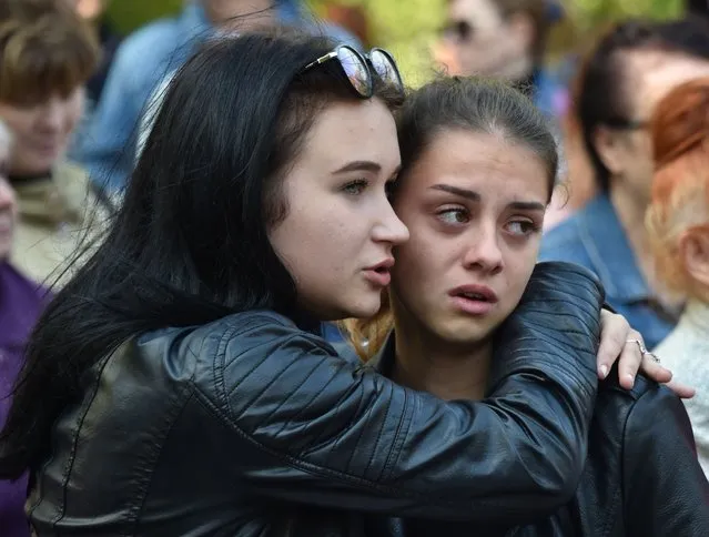 Two girls attend a church service for the victims of a college attack in Kerch, Crimea, on October 18, 2018, after a student opened fire at a technical college in the Russian- annexed Crimea city of Kerch. A teenage gunman shot dead at least 18 people and injured dozens before killing himself at a technical college where he was a student in Russian- annexed Crimea on October 17. (Photo by Andrey Petrenko/AFP Photo)