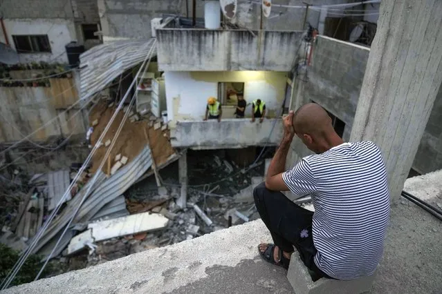 Palestinians inspect a damaged building following an Israeli army raid in Nour Shams refugee camp in the northern West Bank, Sunday, September 24, 2022. Palestinians said at least two people were killed in the raid, which the army said was carried out to destroy a militant command center and bomb-storage facility in the building. (Photo by Majdi Mohammed/AP Photo)