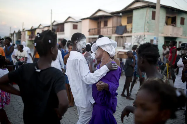 In this Noveber 1, 2018 photo, voodoo believers who are supposed to be possessed with Gede spirit dance in the middle of the street during the annual Voodoo festival Fete Gede at Cite Soleil Cemetery in Port-au-Prince, Haiti. The characteristics of this traditional celebration, the flamboyant customes and the white-powdered faces of the priests in trance inspired some of the first Hollywood stories about zombies. (Photo by Dieu Nalio Chery/AP Photo)