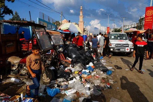 Palestinians walk past piles of garbage that threaten to spark an environmental catastrophe, amid the ongoing Israeli-Palestinian conflict, in Khan Younis in the southern Gaza Strip on October 16, 2023. (Photo by Mohammed Salem/Reuters)