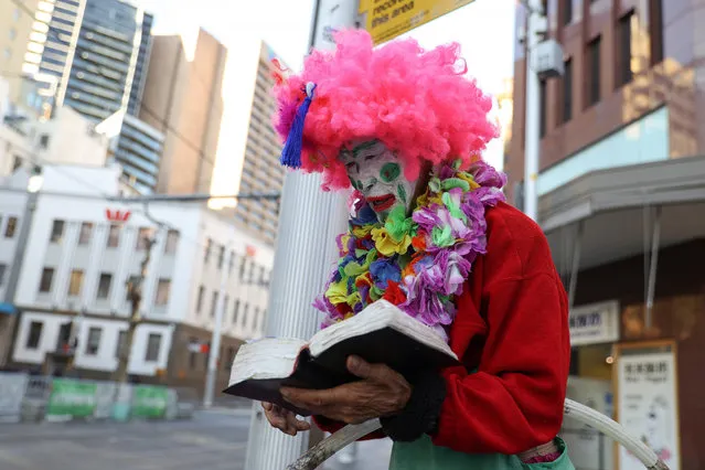 A street performer takes a break from hula hooping to read from the Bible in the city centre of Sydney, Australia, June 2, 2021. (Photo by Loren Elliott/Reuters)