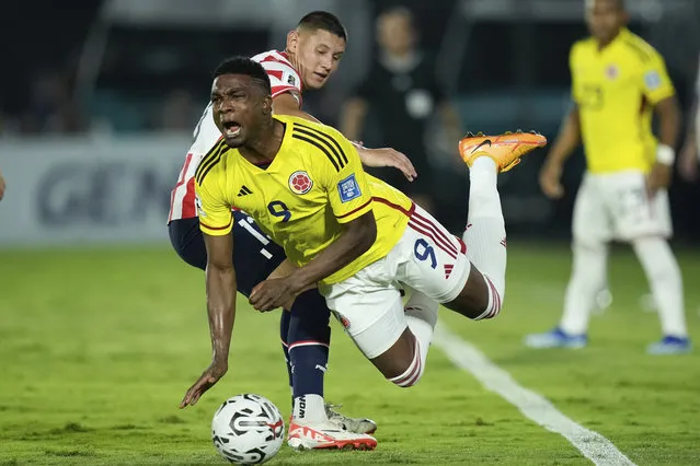 Colombia's Jhon Cordoba falls challenged by Paraguay's Omar Alderete during a qualifying soccer match for the FIFA World Cup 2026 at the Defensores del Chaco stadium in Asuncion, Paraguay, Tuesday, November 21, 2023. (Photo by Jorge Saenz/AP Photo)