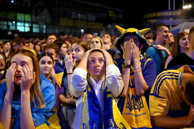 Ukraine's fans react as they watch on a giant screen the broadcast of the UEFA EURO 2020 quarter-final football match between England and Ukraine at the fanzone in the center of Kiev on July 3, 2021. England thrashed Ukraine 4-0 to set up a Euro 2020 semi-final against Denmark. (Photo by Sergei Supinsky/AFP Photo)