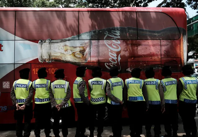 A tourist bus with Coca-cola advertisement is seen as Indonesian police women stand guard during student protests in Jakarta, Indonesia, January 12, 2017. (Photo by Reuters/Beawiharta)