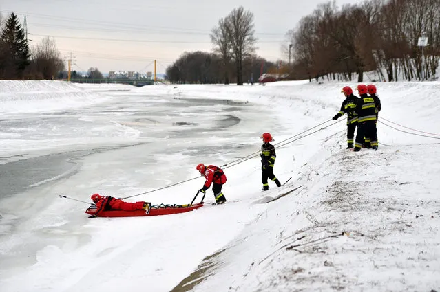 Firemen drag the body of a man out of the Wislok river in Rzeszow, south east Poland, 13 Jabuary 2017. Police confirmed that it is the body of 25-year-old student from a local college, a resident of the Bieszczady region, who disappeared in unclear circumstances in November 2016. (Photo by Darek Delmanowicz/EPA)