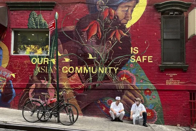 Two chefs rest against a mural during their cigarette break in the Chinatown area of Manhattan on Monday, August 9, 2021, in New York. (Photo by Wong Maye-E/AP Photo)
