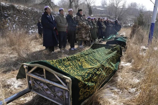 Ma Lianqiang, left, stands near the body of his wife Han Suofeiya, who was killed in Monday night's earthquake in Yangwa village near Dahejia town in northwestern China's Gansu province, Wednesday, December 20, 2023. A strong overnight earthquake rattled a mountainous region of northwestern China, authorities said Tuesday, destroying homes, leaving residents out in a below-freezing winter night and killing many in the nation's deadliest quake in nine years. (Photo by Ng Han Guan/AP Photo)