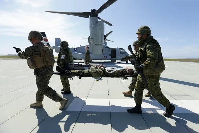Soldiers from Japan's Ground Self Defense Force carry a fellow soldier simulating a casualty, to an awaiting Osprey aircraft as they train alongside U.S. Navy medics and U.S. Marines during the bilateral annual Iron Fist military training exercise in Camp Pendleton, California February 26, 2016. (Photo by Mike Blake/Reuters)