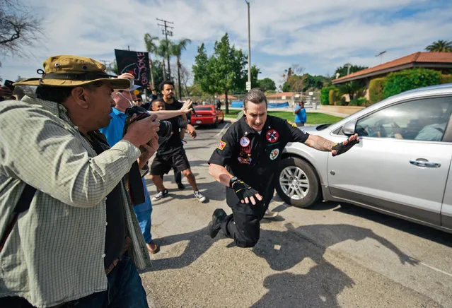 In this photo provided by OC Weekly a falling Ku Klux Klansman gets shoved by a counter-protester behind him, after members of the KKK tried to start an anti-immigration rally at Pearson Park in Anaheim on Saturday, February 27, 2016. Three people were stabbed Saturday, one critically, after a small group of Ku Klux Klan members staging an anti-immigrant rally clashed with a larger gathering of counter-protesters, police said. (Photo by Eric Hood/OC Weekly via AP Photo)