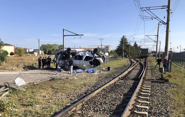 Security officers investigate the crash site in Ergene, Tekirdag province, Turkey, Saturday , September 4, 2021. A collision between a freight train and a minibus in northwest Turkey killed six people and injured eight others Saturday, Turkish news agency Demiroren reported. The crash at a railroad crossing in Ergene involved a minibus carrying factory workers and a train headed to nearby Cerkezkoy at 8 a.m. local time (0500 GMT), the news agency said. (Photo by IHA via AP Photo)