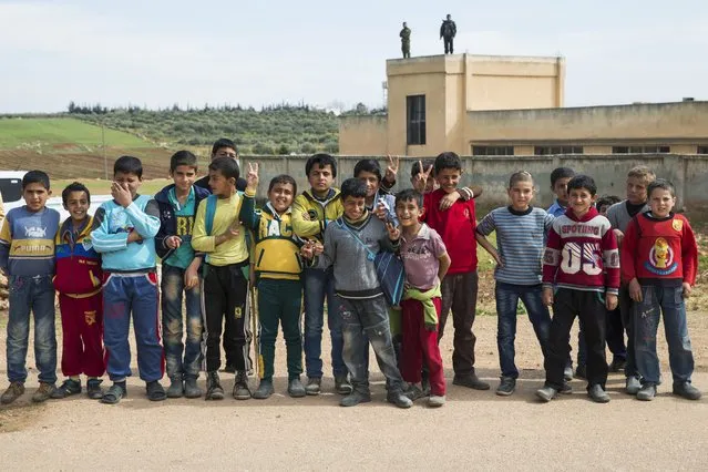 Syrian children pose for a picture in Maarzaf, about 15 kilometers west of Hama, Syria, Wednesday, March 2, 2016. (Photo by Pavel Golovkin/AP Photo)