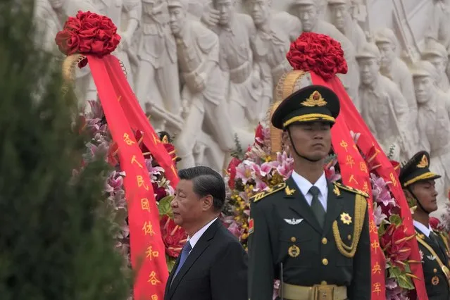Chinese President Xi Jinping walks past wreaths of flowers and a member of an honor guard after he paid respect to the Monument to the People's Heroes during a ceremony to mark Martyr's Day at Tiananmen Square in Beijing, Thursday, September 30, 2021. (Photo by Andy Wong/AP Photo)
