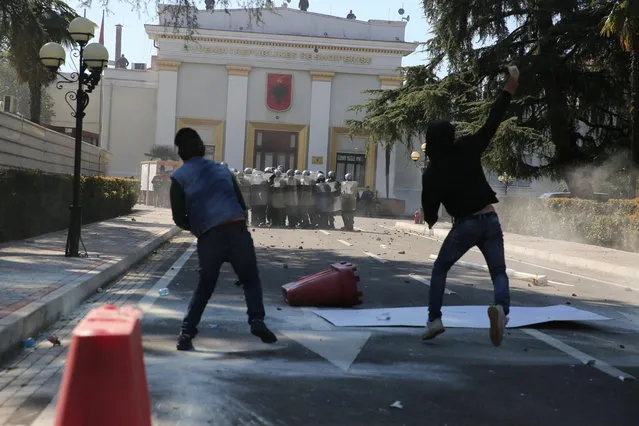 Protesters throw stones at riot police as thousands of opposition supporters protest in Tirana, Albania on Saturday, March 16, 2019. (Photo by Visar Kryeziu/AP Photo)