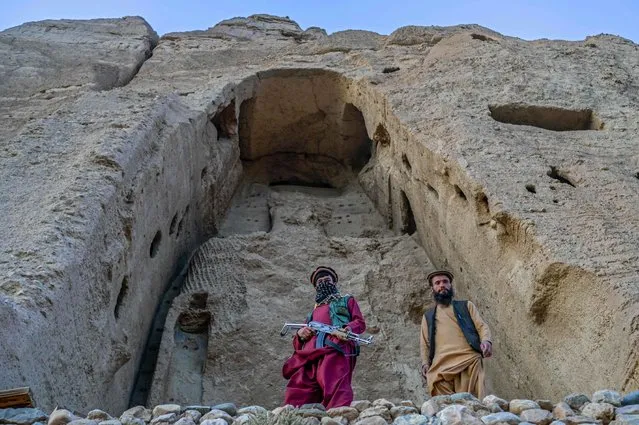 Members of Taliban stand in front of the site where the Shahmama Buddha statue once stood before being destroyed by the Taliban in March 2001, in Bamiyan province on October 2, 2021. (Photo by Bulent Kilic/AFP Photo)