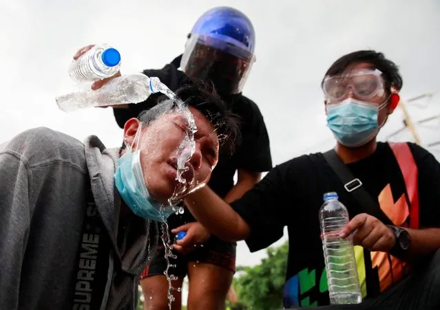 Demonstrators pour water onto their colleague's face as they help him during a protest over the Thai government's handling of the coronavirus disease (COVID-19) pandemic and to demand Prime Minister Prayuth Chan-ocha's resignation, in Bangkok, Thailand, September 27, 2021. (Photo by Soe Zeya Tun/Reuters)