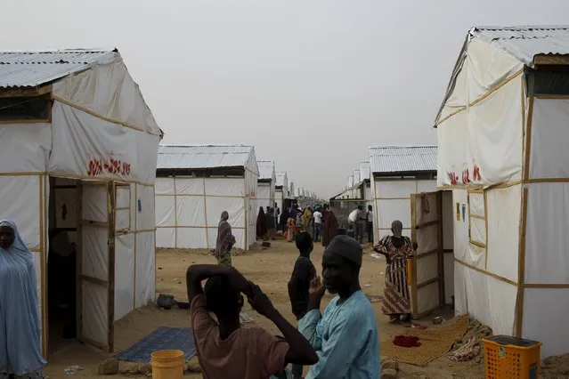 People walk near makeshift accommodation at Bakassi Camp for internally displace people in Maiduguri, Nigeria March 8, 2016. (Photo by Afolabi Sotunde/Reuters)