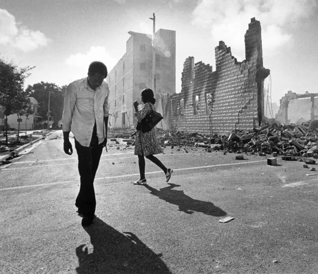 In this May 19, 1980, photo, people walk past ruins in the Culmer section of Miami after rioting over the acquittal of four police officers charged with the 1979 beating death of Arthur McDuffie, a black motorcyclist. When future Virginia Gov. Ralph Northam and future Attorney General Mark Herring admitted dressing up in blackface in the 1980s racial stereotypes and racist imagery in popular culture seemed to be everywhere. There also was racial unrest and historic elections of black mayors. (Photo by Kathy Willens/AP Photo)